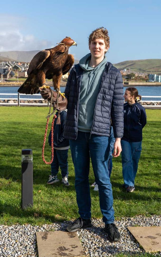 A young man smiling with a bird