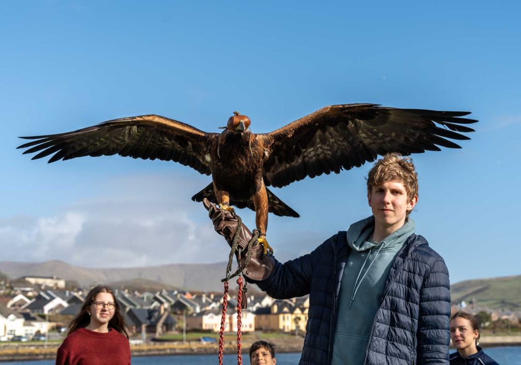 A young man holding a large bird
