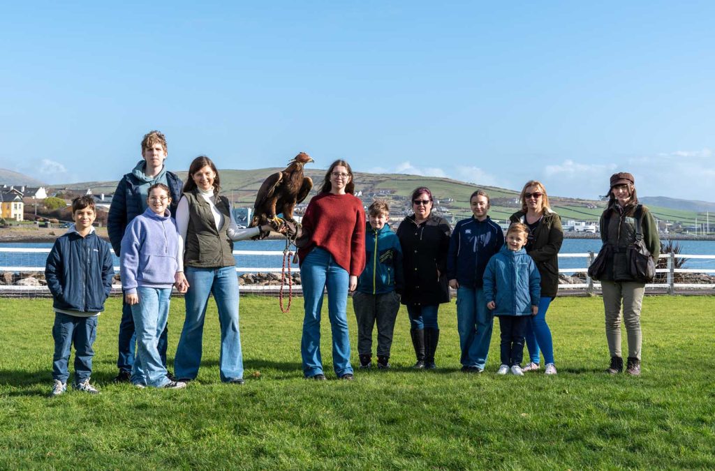 A happy group enjoying posing with a bird