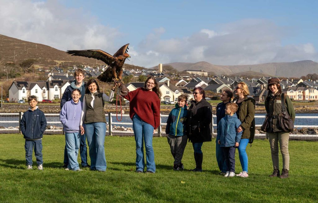 A group of people posing for a photo with a bird
