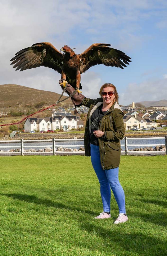 A woman holding a bird that is about to take flight