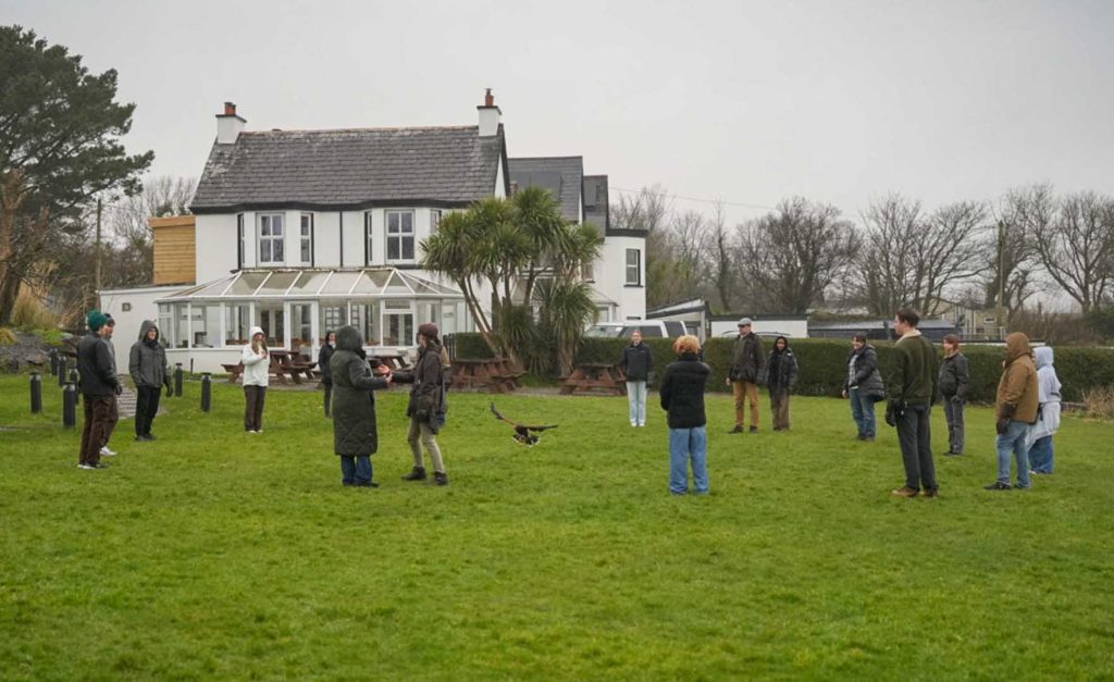 A group watching a demonstration under grey skies